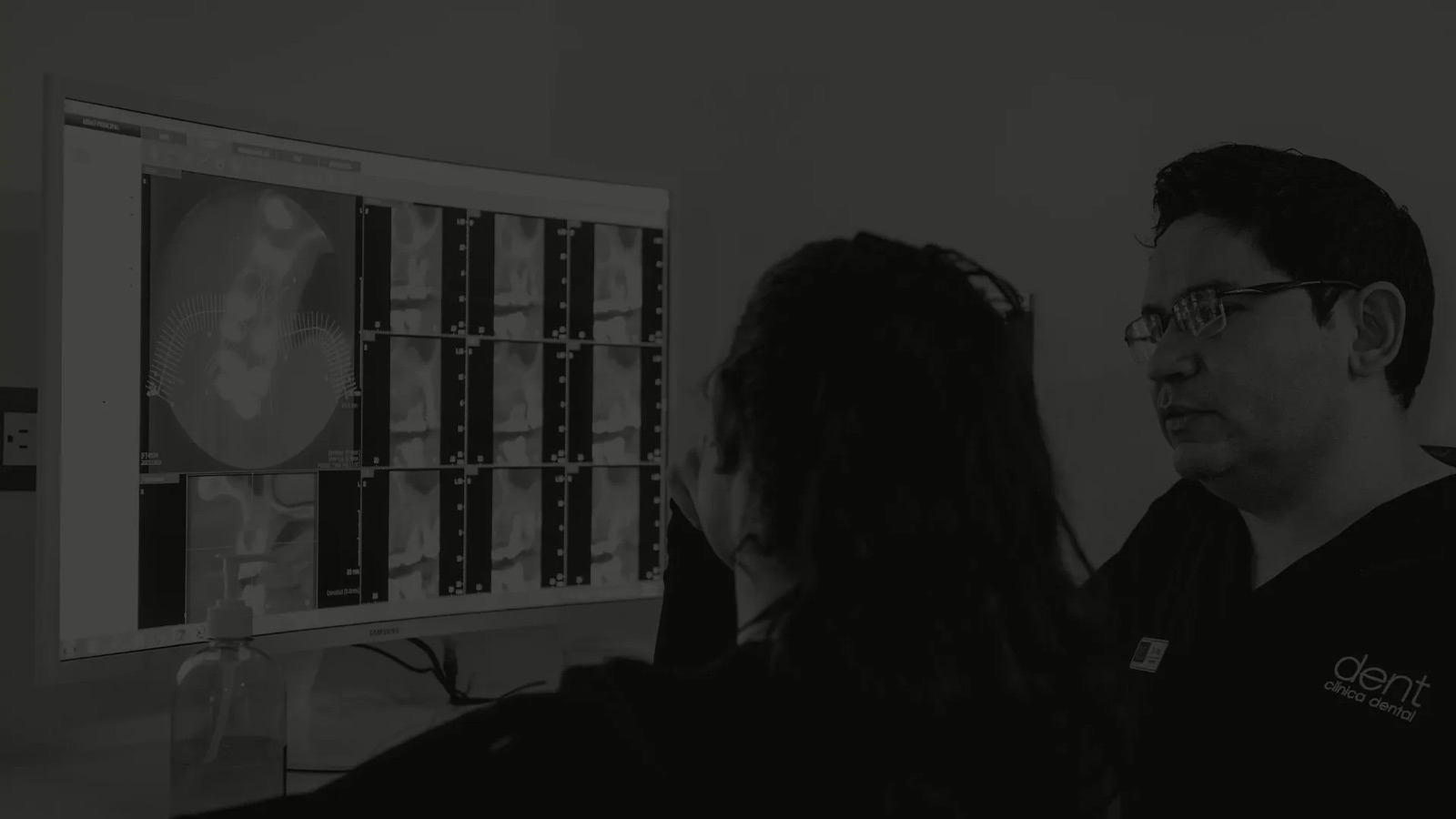 Odontólogo y paciente observan radiografías dentales en el monitor del consultorio