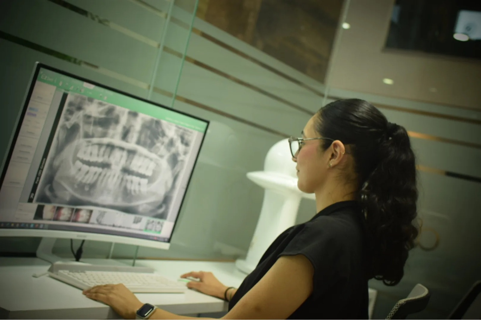 Profesional de Grupo Médico Dent revisa una radiografía panorámica dental en la pantalla del área de diagnóstico