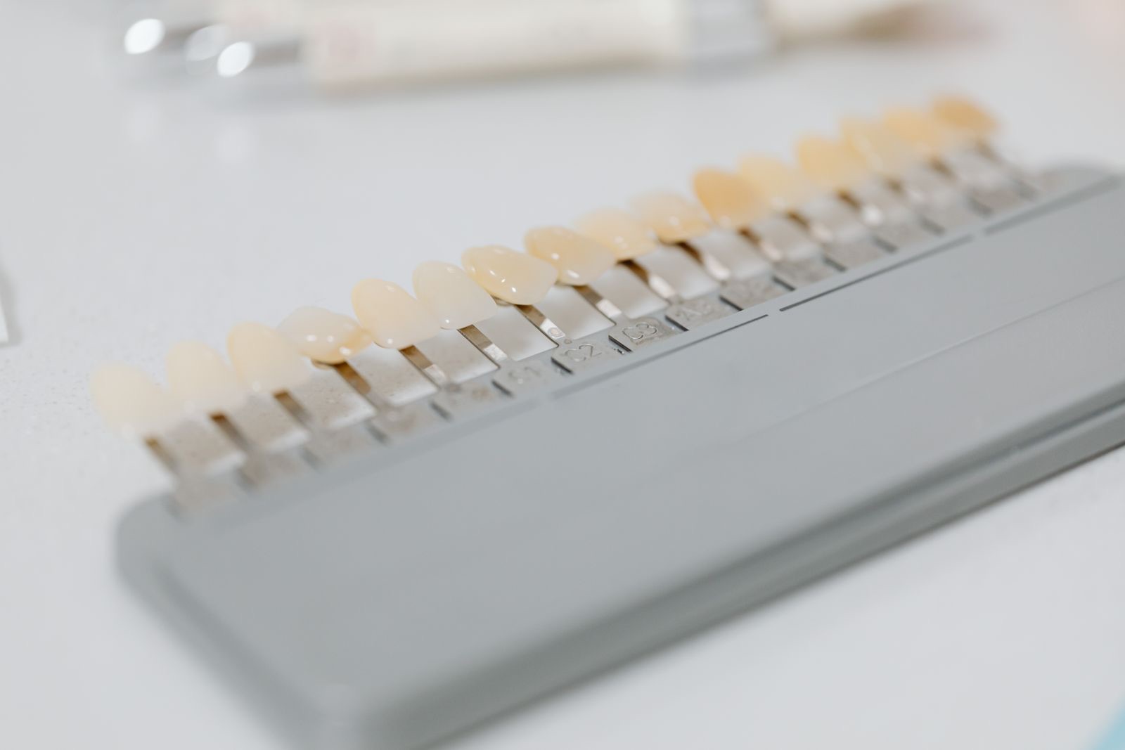 Guía de color dental con muestras de distintos tonos de diente sobre una superficie blanca de consultorio