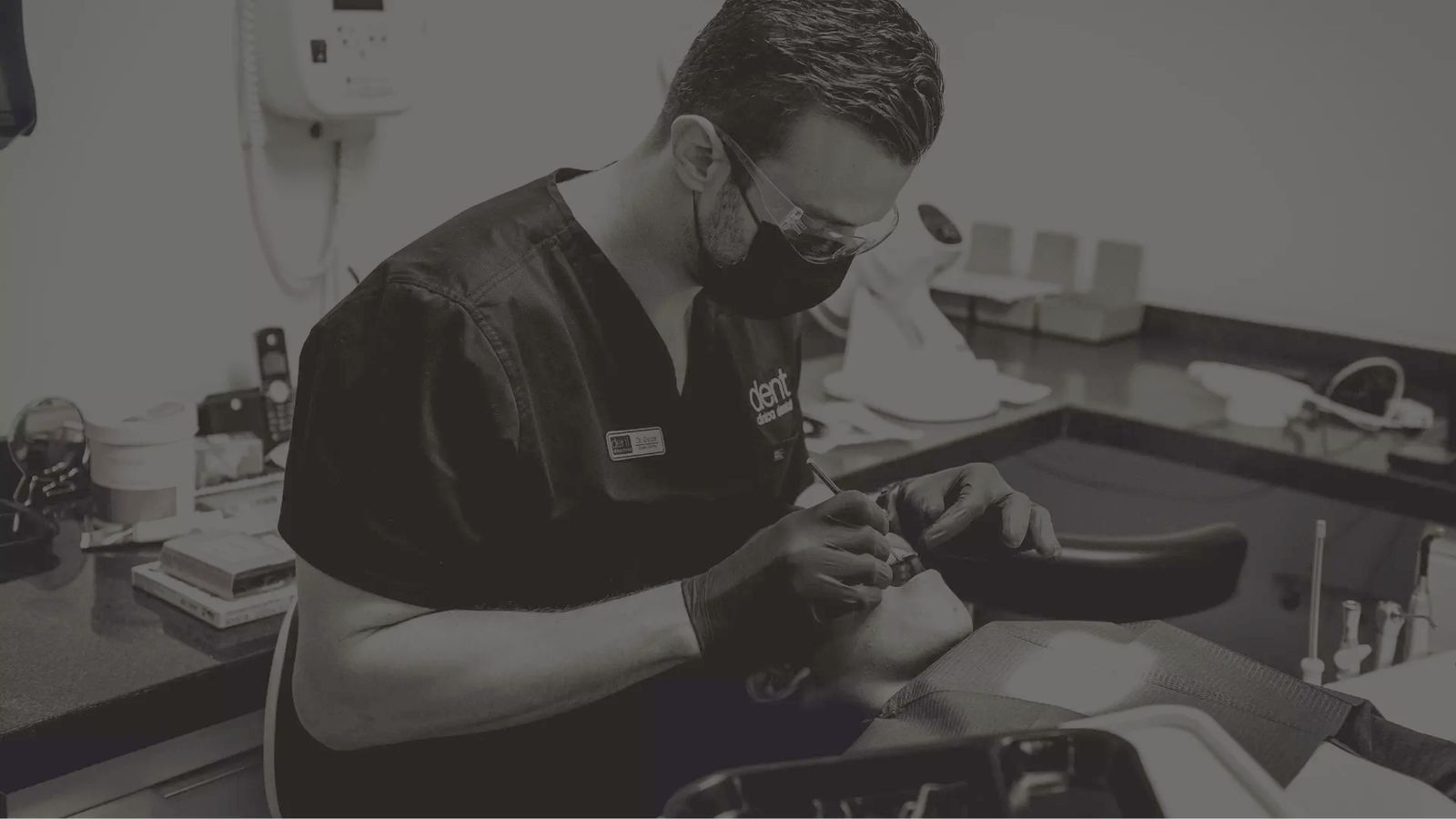 Dentista de Dent Clínica trabaja con instrumentos sobre un paciente en el sillón de una sala de tratamiento